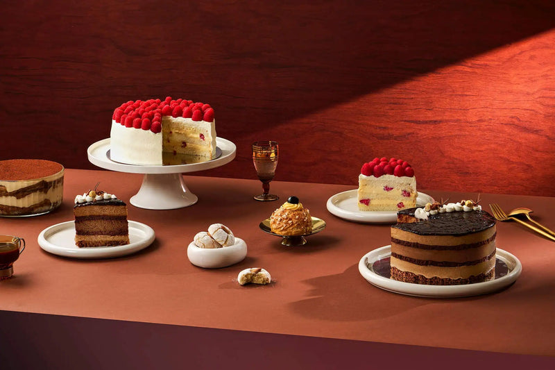 Assorted cakes on a wooden table with a warm color scheme